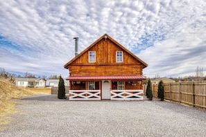 Eine Holzhütte mit rotem Dach, zwei Fenstern und einem Schornstein.