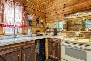 Eine Küche mit Holzwänden, einer Marmorarbeitsplatte und diversen Kaffeeutensilien.