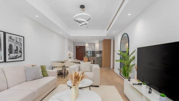Ein modernes Wohnzimmer mit Sofa, Couchtisch und Flachbildfernseher.