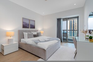 Ein modernes Schlafzimmer mit einem Bett, Nachttischen, einem großen Fenster und Blick auf Gebäude.