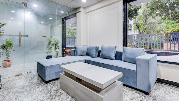 A modern interior with a sectional sofa, a coffee table, and a glass partition.
