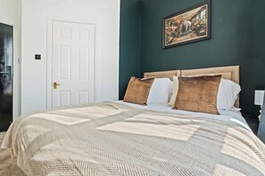 A bedroom with a bed, a door, and a wall-mounted picture. - Comfy Double Studio with Parking | Coventry CV2 (Coventry)