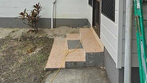 A residential building with a covered patio area, a small plant, and a ladder. - Home in Siusega - Vonnys Garden House (Vaitele)