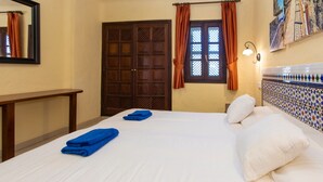 A hotel room with a bed, a nightstand, a window with curtains, a wall-mounted light, and a decorative tile wall. - Apartment in Bahia Feliz by Playa del Aguila (San Bartolomé de Tirajana)