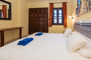 A hotel room with a bed, a nightstand, a window with curtains, a wall-mounted light, and a decorative tile wall. - Apartment in Bahia Feliz by Playa del Aguila (San Bartolomé de Tirajana)