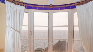 A room with a curved bench, a round table, and a bottle. - Apartment in Bahia Feliz by Playa del Aguila (San Bartolomé de Tirajana)