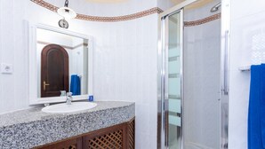A bathroom with a granite countertop sink, a mirror, a shower with a glass door, and a towel rack. - Apartment in Bahia Feliz by Playa del Aguila (San Bartolomé de Tirajana)