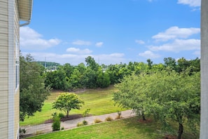A residential area with a grassy lawn, trees, and a paved driveway. - Havens 1136 Back on Program! Beautiful & Spacious! In Barefoot Resort! (North Myrtle Beach)
