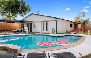 A backyard with a swimming pool, a covered patio, and a barbecue area. - Grandscape District Stay w/ Game Room, BBQ & Pool (The Colony)
