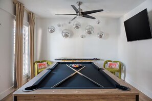 A pool table with a ceiling fan, disco balls, and a TV on the wall. - Grandscape District Stay w/ Game Room, BBQ & Pool (The Colony)