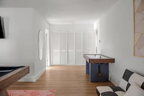 A modern room with a pool table, a sofa, and a view of a white closet. - Grandscape District Stay w/ Game Room, BBQ & Pool (The Colony)