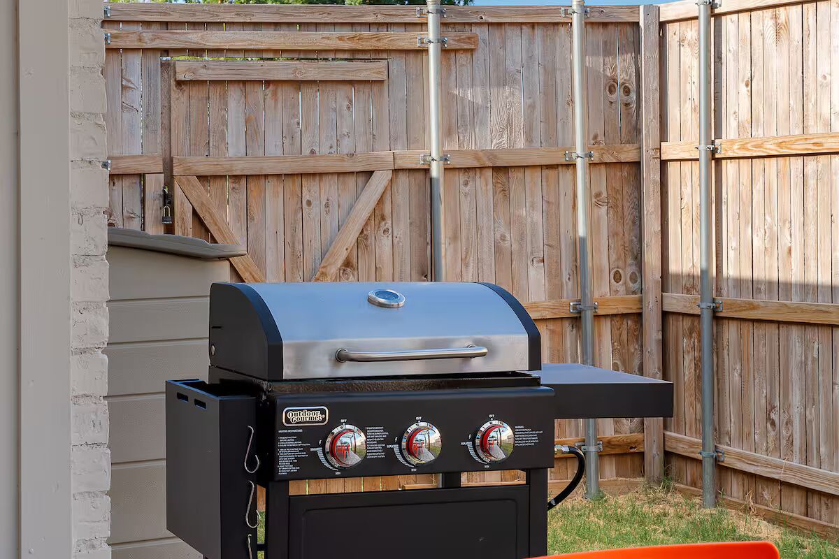 Una parrilla portátil para exteriores con pantalla digital y tres perillas de control.