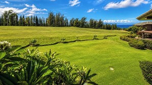 Ein Golfplatz mit einem Haus im Hintergrund.