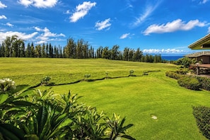 Ein Golfplatz mit einem Haus im Hintergrund.