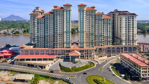 A multi-story residential building with a central courtyard and a river in the background.