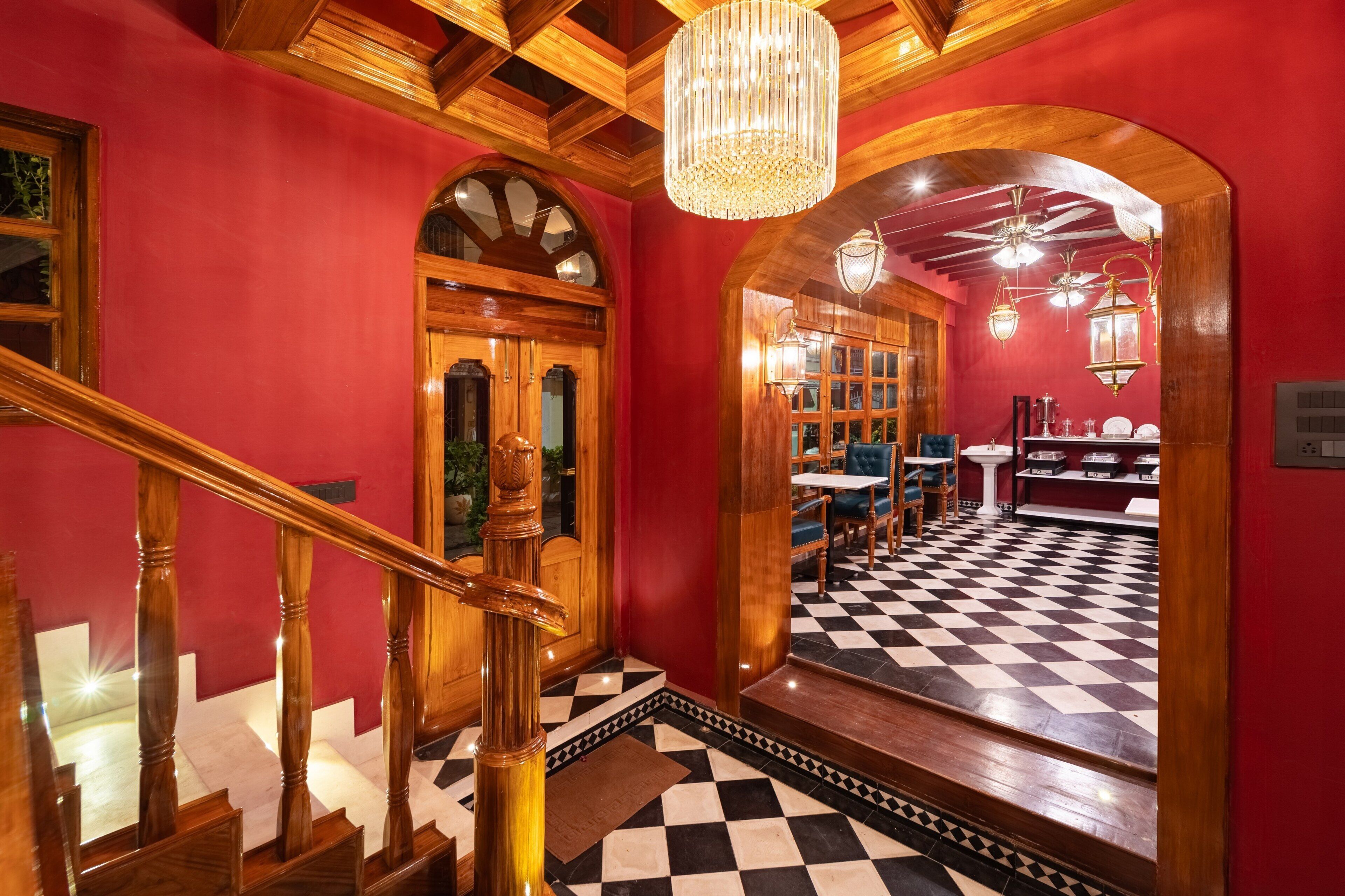A staircase with wooden balusters, a chandelier, and a checkered floor.