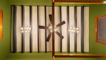 Une pièce dotée d’un ventilateur de plafond, d’une structure en bois et d’un mur vert.