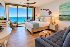 A modern hotel room with a large bed, a seating area with a sofa and chairs, a dining table, and a view of the ocean. - Mahana | 3 Oceanfront Villas, Sleeps 10 | Car Incl. w/ 6+ Nights | ML-4208 by KBM (Lahaina)