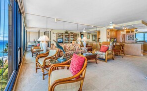 A spacious living area with wicker furniture, a television, and a view of the ocean. - Mahana | 3 Oceanfront Villas, Sleeps 10 | Car Incl. w/ 6+ Nights | ML-4214 by KBM (Lahaina)