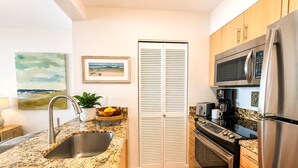 A modern kitchen with granite countertops, stainless steel appliances, and wooden cabinets. - Mahana | 3 Oceanfront Villas, Sleeps 10 | Car Incl. w/ 6+ Nights | ML-4214 by KBM (Lahaina)