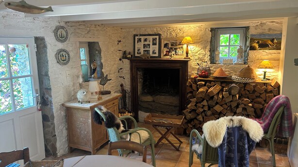 Una habitación acogedora con chimenea, una mesa de comedor y una ventana con vistas.