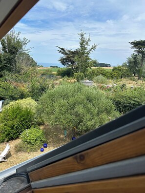 A view from a window overlooking a garden with various plants and a small shed. - House located 700 meters from Grands-Sables Beach, accessible via a country lane and featuring an enclosed garden (Locmaria)