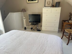 A bedroom with a bed, a television, a dresser, and a chair. - House located 700 meters from Grands-Sables Beach, accessible via a country lane and featuring an enclosed garden (Locmaria)