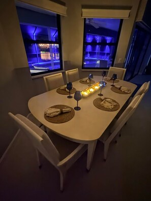 Ein Esstisch mit modernem Design, gedeckt mit Geschirr, Weingläsern und einer zentralen Leuchte.