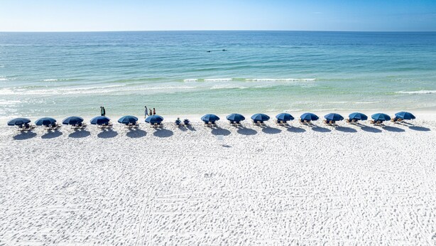 A beach with rows of umbrellas and people. - Sundestin 1014 1 Bedroom Condo (Destin)
