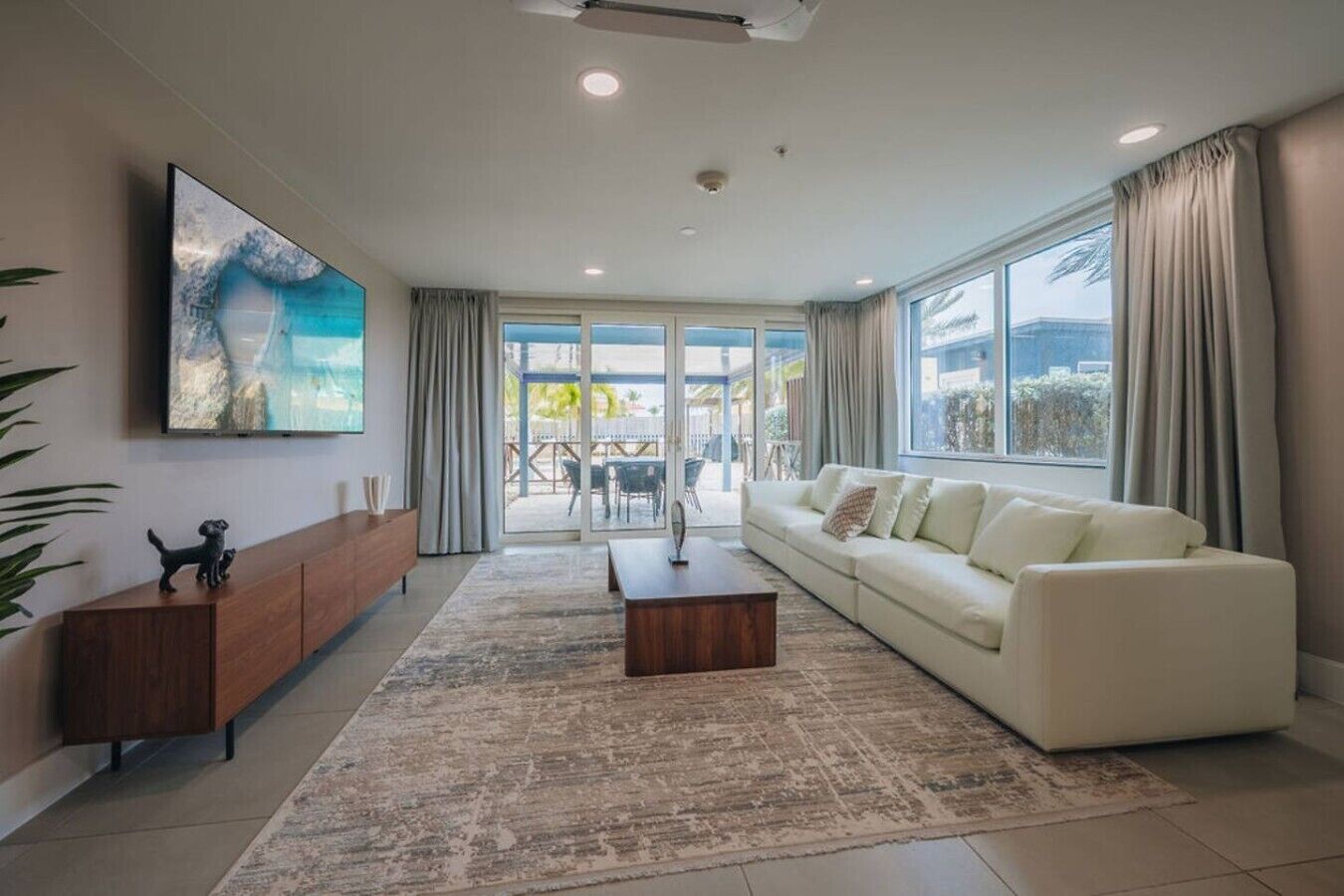 A modern living room with a sofa, coffee table, and a TV mounted on the wall.