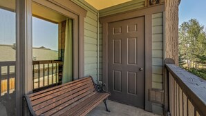A wooden bench outside a building with a door and a window. - Phoenix 219 – Your Gondola-Side Mountain Retreat in Steamboat Springs! (Steamboat Springs)