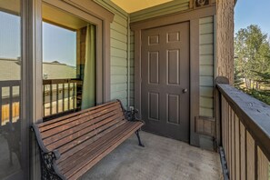 A wooden bench outside a building with a door and a window. - Phoenix 219 – Your Gondola-Side Mountain Retreat in Steamboat Springs! (Steamboat Springs)
