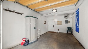 A garage with a concrete floor, white walls, a wooden ceiling, and a blue banner. - Phoenix 219 – Your Gondola-Side Mountain Retreat in Steamboat Springs! (Steamboat Springs)