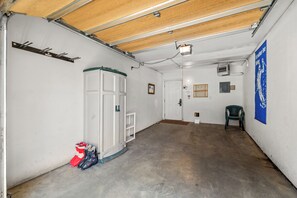 A garage with a concrete floor, white walls, a wooden ceiling, and a blue banner. - Phoenix 219 – Your Gondola-Side Mountain Retreat in Steamboat Springs! (Steamboat Springs)