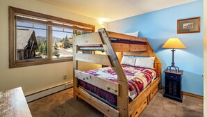 A bunk bed with a view of a building and trees through a window. - Phoenix 219 – Your Gondola-Side Mountain Retreat in Steamboat Springs! (Steamboat Springs)