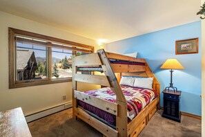 A bunk bed with a view of a building and trees through a window. - Phoenix 219 – Your Gondola-Side Mountain Retreat in Steamboat Springs! (Steamboat Springs)