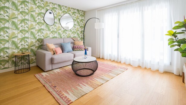 A living room with a sofa, round coffee table, and a patterned rug. - Apartment in Las Palmas Near Playa Alcaravaneras (Las Palmas de Gran Canaria)