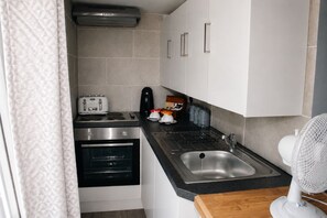 A compact kitchen with a toaster, coffee maker, and a sink. - The Lobster Pots - Bawtry (Bawtry)