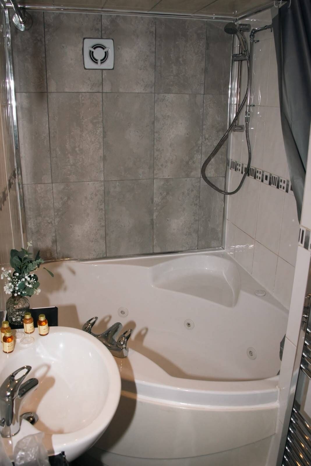 Un baño con bañera, lavamanos y ducha.