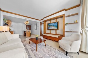 A modern living room with a sofa, armchairs, a coffee table, and a TV mounted on the wall. - Private Residence at Carillon Resort - 910 (Miami Beach)
