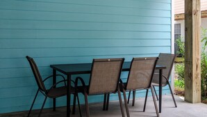 A table with four chairs against a turquoise wall, a wooden post, and a window with blinds. - Inviting Single Family Home Near Beach - K403 (Kure Beach)