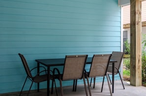 A table with four chairs against a turquoise wall, a wooden post, and a window with blinds. - Inviting Single Family Home Near Beach - K403 (Kure Beach)