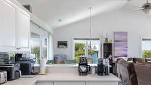 Una cocina moderna con una isla central, electrodomésticos integrados y vistas al exterior.