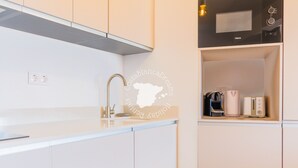 Eine moderne Küche mit weißen Schränken, einer Edelstahl-Spüle und einer Mikrowelle.