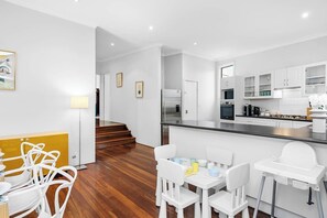 Polished timber floors transition beautifully into a raised hallway stairs area, connecting the kitchen and dining zones to the rest of the home's living quarters. - Classic Australian Charm (East Victoria Park)