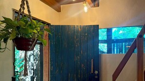A room with a wooden ceiling, a hanging plant, a door with a rustic finish, and a staircase. - Cozy, comfy house in the heart of Caraíva - fully equipped and peaceful located (Caraíva)