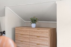 A wooden dresser with drawers and a potted plant on top. - MINNeSTAY* Magnolia House (Minneapolis)
