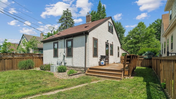 A two-story house with a wooden deck, a satellite dish, and a small garden area. - MINNeSTAY* Magnolia House (Minneapolis)