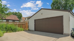 A residential garage with a brown door, a number '5340' on the wall, and a wooden fence in the background. - MINNeSTAY* Magnolia House (Minneapolis)