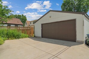 A residential garage with a brown door, a number '5340' on the wall, and a wooden fence in the background. - MINNeSTAY* Magnolia House (Minneapolis)